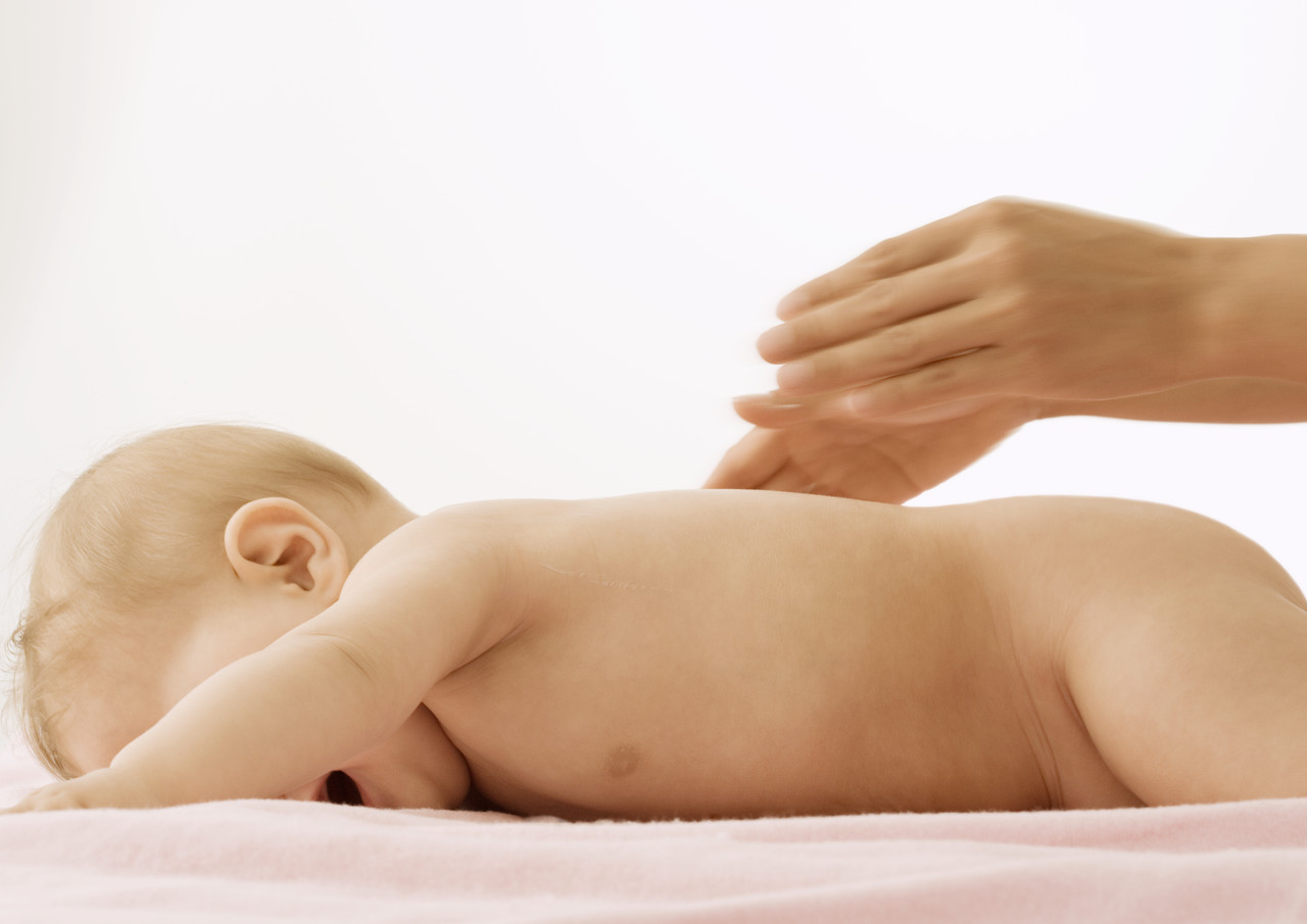 Baby Lying on Stomach, Hands Posed Over Baby for Massage, by Frederic Cirou/PhotoAlto/Corbis