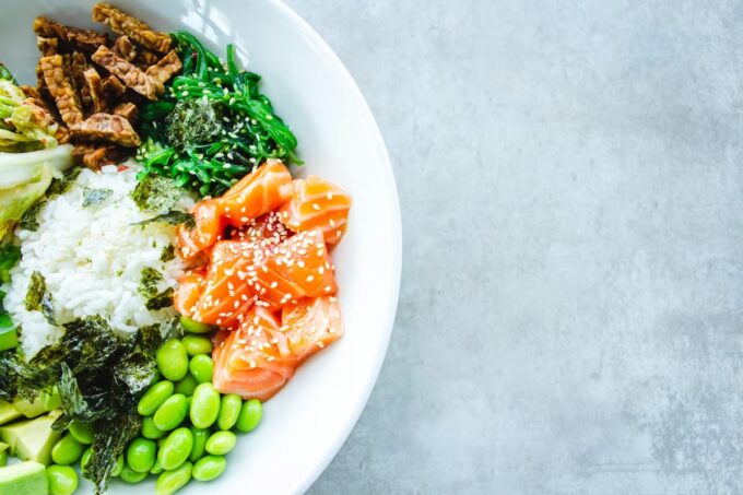 piatto sano con alga wakame, edamame, salmone, tempeh e riso